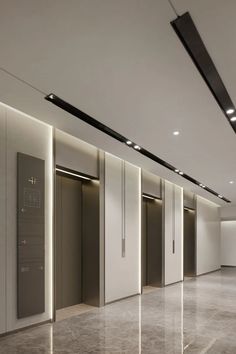 an empty room with several doors and lights on the ceiling is lit by recessed lighting