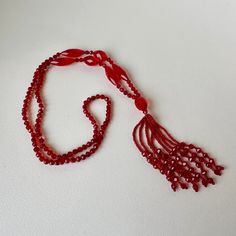 Beautiful, shimmering ruby red glass (likely crystal) beaded sautoir necklace. Art Deco era. A sautoir is a French term for a long necklace that suspends a tassel or other ornament. This amazing vintage collectible will add drama to a dress, tunic or even a t-shirt & jeans. In excellent vintage condition. No chips or imperfections. Necklace approximately 38" long, tassel is 4" long. Elegant Red Long Necklace With Round Beads, Vintage Red Necklace For Celebration, Red Vintage Necklace For Celebration, Elegant Red Long Necklace For Gift, Elegant Handmade Red Long Necklace, Elegant Red Long Necklace, Vintage Lariat Beaded Necklace Gift, Vintage Lariat Beaded Necklaces For Gifts, Vintage Lariat Beaded Necklace As A Gift