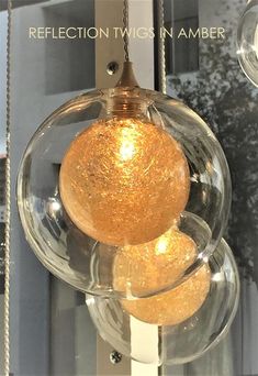 a glass ball hanging from the side of a door with chains around it and an inscription reflection twins in amber