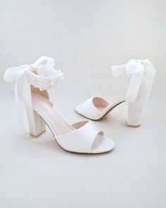 Satin block heel wedding sandals adorned with all over pearls ribbon strap . Elegance and feminine inspired wear for your special day. The delicate pearl beads are placed to create a graceful classic style. Simple and easy wear for bridal wear, bridesmaids, holiday party, wedding parties, and any special occasions. The light blue color can easily be your something blue.DETAILS:HEELS: 3.75 inchesCOLORS AVAILABLE: Ivory, White and Light BlueUPPER: Synthetic upper and liningMATERIALS: Manmade outso Shoes For Brides, Bridal Flats, Shoes Heels Classy, Satin Shoes, Bridal Sandals, Wedding Guest Shoes, Heels Classy, Wedding Sandals, Glitter Shoes