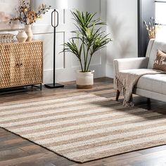 a living room area with a couch, rug and side table in front of a window