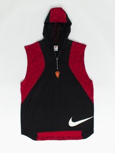 90s vintage Nike basketball vest / sleeveless hoodie black and red zig zag print. This Nike basketball hoodie features a red zigzag pattern, a quarter zip, mesh fabric inside the hood and the classic big swoosh Nike tick at the bottom of the jersey. Cool orange embroidered basket ball and hoop at base of zip. Perfect for shooting some hoops or general streetwear. Our recommended size: Large Label says: Large Condition: Very good Material (body): 100% cotton Material (lining): 100% polyester Meas Casual Streetwear Vest With Dropped Armholes, Sleeveless Black Hoodie In Athleisure Style, Sleeveless Black Athleisure Hoodie, Black Hooded Vest For Streetwear, Throwback Sports Hoodie Top, Black Sportswear Vest For Streetwear, Throwback Hooded Sports Top, Hooded Vest Top For Streetwear, Black Athleisure Vest For Streetwear