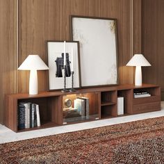 a living room with two lamps and a book shelf on the floor next to a rug