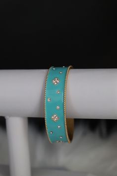 The Turquoise Cuff Bracelet boasts a captivating design with vibrant turquoise stones intricately embedded in a sleek cuff. This accessory effortlessly combines a pop of color with a chic and versatile style, making it a statement piece for any fashion ensemble. Size: 6 3/4 inches - Inner Diameter Closure: Bangle Hinge Bracelet Material: Brass with 18K Gold Plating with Rhodium Coating Lead Free and Hypoallergenic Elegant Adjustable Turquoise Bangle, Trendy Turquoise Bracelets For Party, Jeweled Bangle Cuff Bracelet, Trendy Turquoise Bangle Jewelry, Trendy Turquoise Metal Bracelets, Turquoise Metal Bangle Cuff Bracelet, Blue Bangle Cuff Bracelet For Party, Turquoise Bracelet Jewelry, Turquoise Bracelet Fashion Accessory