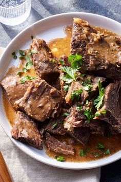 a white plate topped with meat and gravy