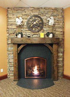 a stone fireplace with a clock on the mantle