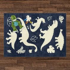 an area rug with dinosaurs and snowflakes in white on a wood floor,