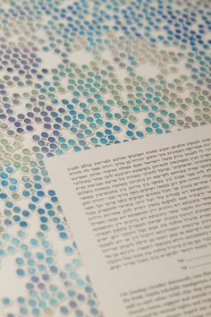 an open book with blue and green dots on it