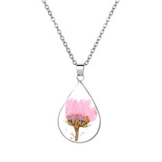 a pink flower in a tear shaped glass pendant on a silver plated necklace chain