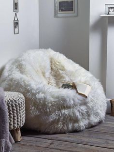 a white bean bag chair sitting on top of a wooden floor next to a lamp