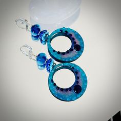 "These big colorful hoop earrings are comprised of enameled hoop charms 38mm across by 43mm in length.  These amazing hoops are done in dark and light blue colors with light blue and dark blue\" bubbles\" by glass artist Carolyn. These colorful hoops dangle below 11mm artisan Lampwork glass beads done in a light transparent blue with etched circles. The earrings are accented with ceramic light and dark blue bead caps, Hill Tribe Silver beads and suspend from sterling silver lever back ear wires. The total length is 3 1/4\". These are beautiful, eye-catching earrings! Make a wonderful gift too! Comes in a pretty gift box with fast shipping." Handmade Blue Round Hoop Earrings, Blue Hoop Earrings With Ear Wire, Blue Beaded Round Hoop Earrings, Blue Beaded Small Hoop Jewelry, Blue Small Hoop Earrings For Pierced Ears, Blue Nickel-free Small Hoop Earrings, Blue Small Hoop Nickel-free Earrings, Handmade Blue Beaded Small Hoop Earrings, Handmade Small Hoop Blue Earrings