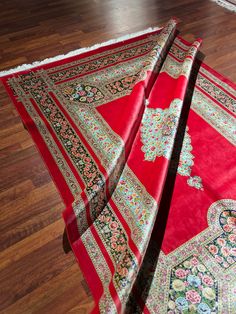 two red rugs laying on the floor next to each other with different designs and colors