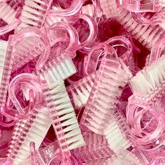 a pile of pink and white plastic hair brushes