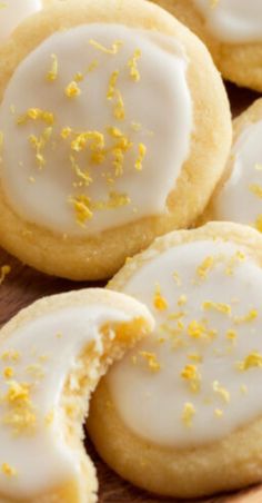 lemon cookies with white icing and yellow sprinkles on a cutting board