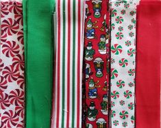 many different colored ties are lined up on the table together, with candy canes in the background