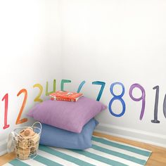 three pillows are stacked on top of each other in front of a wall with numbers