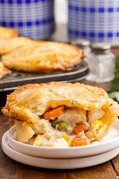 a plate with a pie on it and some other food items in the back ground