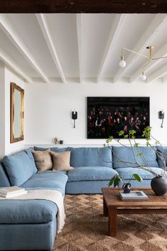 a living room filled with furniture and a large painting on the wall above it's couch