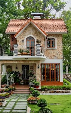 a house with lots of plants and flowers in the front yard