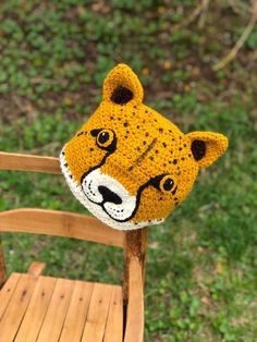 a crocheted tiger head sitting on top of a wooden chair