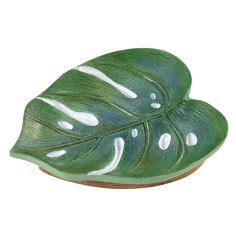 a green leaf shaped bowl with white spots on it