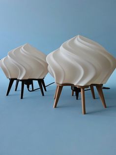 three white sculptures sitting on top of each other in front of a blue background,