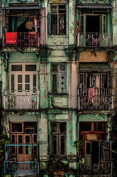 an old building with multiple balconies and balcony railings, painted in shades of green