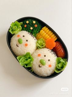 two rice balls with vegetables in the shape of faces