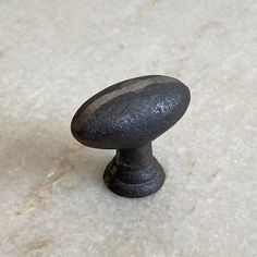 an old black door knob on a white marble counter top with no one around it