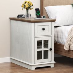 a bed with a wooden headboard and night stand on top of it next to a nightstand