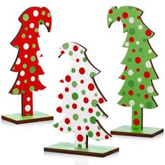 three wooden christmas trees with polka dots on them, one is green and the other is red