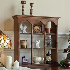 a wooden shelf with candles and other items on it