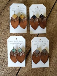 four pairs of leather earring designs on display in front of a wooden table with price tags