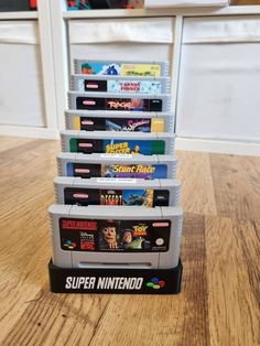 a stack of nintendo games sitting on top of a wooden table