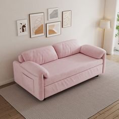 a pink couch sitting on top of a rug in a living room