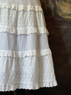 This historically inspired maxi skirt is the perfect base to build all of your historical looks upon. Crafted in dainty floral embroidered cotton, & adorned with layers of delicate lace trim; the tiered silhouette & stretchy waistband of this skirt are perfect for accommodating a day of frolicking in the field outside your cottage! Sizing: ✧IN✧ Waist Hips Length S/M 25-38 Inches Up to 56 Inches 32 Inches L/XL 30-42 Inches Up to 60 Inches 32 Inches ✧CM✧ Waist Hips Length S/M 62.5-95 CM Up to 140 CM 80 CM L/XL 75-105 CM Up to 150 CM 80 CM Materials:Outer - 70% Cotton, 30% Polyester. Lining - 100% Cotton. Care:Machine wash on gentle cycle with like colors. Tumble or air dry. Please be aware that this item was photographed using a petticoat or similar undergarments. Summer Lace Maxi Skirt With Ruffles, Peasant Style Ruffled Maxi Skirt, Spring Tiered Maxi Skirt With Lace Trim, Spring Lace Trim Tiered Maxi Skirt, Lace Tiered Maxi Skirt With Ruffles, Lace Maxi Skirt With Ruffles And Tiered Design, Summer Tiered Maxi Skirt With Lace Patchwork, Tiered Maxi Skirt With Lace Patchwork For Summer, Bohemian Tiered Skirt With Lace Trim