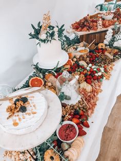 a buffet table filled with lots of food and desserts on top of white tables