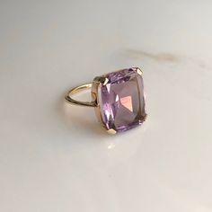 A 9 carat yellow gold Amethyst ring. This beautiful piece displays a gorgeous purple stone in the clutches of a striking gold setting. CONDITION: Minor wear can be seen on face. Condition consistent with age and use. Please see photos for more detail. STONE SIZE: 13mm x 15mm BAND WIDTH: 1mm SETTING HEIGHT: 5mm RING SIZE: UK: M | US: 6 1/4 WEIGHT: 4.2 grams Luxury Yellow Gold Amethyst Ring, Luxury Vintage Amethyst Ring, Luxury Yellow Gold Amethyst Ring With Accent Stones, Elegant Lavender Amethyst Ring In 14k Gold, Formal 14k Gold Amethyst Ring, Luxury Purple Amethyst Ring For Formal Occasions, Classic Yellow Gold Rectangular Amethyst Ring, Yellow Gold Rectangular Amethyst Ring For Anniversary, Evening 14k Gold Gemstone Rings