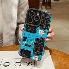 a person holding up a phone case that has been painted with black and blue designs