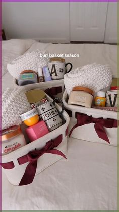 two white baskets filled with personal care items on top of a bed next to each other