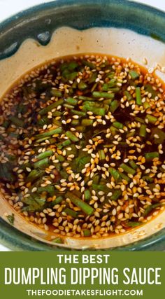 the best dumpling dipping sauce with sesame seeds in a green bowl on a white table