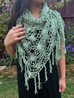 Embrace the magic of nature with the Floral Web Wrap Shawl; a hand-crocheted masterpiece adorned with intricate floral patterns and whimsical fringe, in a gorgeous seafoam green. This generously sized triangle shawl offers the perfect blend of style and comfort, effortlessly elevating your look, whether you're dancing under festival lights or savoring a cool evening outdoors. Crafted from soft, lightweight yarn, it drapes beautifully over your shoulders, providing cozy warmth without sacrificing Spring Bohemian Crochet Shawl, Bohemian Shawl With Crochet Lace, Handmade Bohemian Shawl For Spring, Bohemian Crochet Lace Shawl For Spring, Spring Festival Crochet Shawl, Crochet Shawl For Spring Festival, Green Shawl For Beach In Spring, Green Shawl For Spring Beach Outings, Green Shawl For Spring Beach Occasions