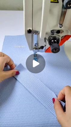 someone is using a sewing machine to sew something on a piece of blue fabric