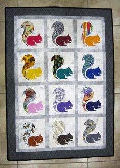 a quilted wall hanging with many different animals on it