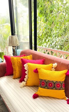 the couch is covered with colorful pillows and pom poms on it's sides