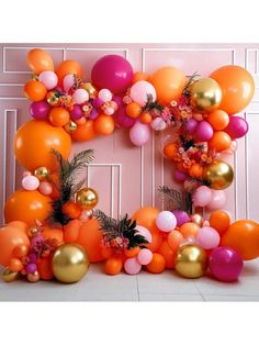 an orange, pink and gold balloon arch