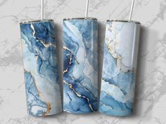 three blue and gold marbled tumbles are hanging on the wall