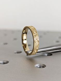 a gold wedding ring sitting on top of a table