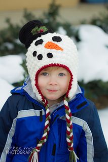 a young boy wearing a crocheted snowman hat