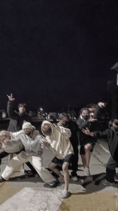 a group of people standing on top of a street next to each other in front of a crowd